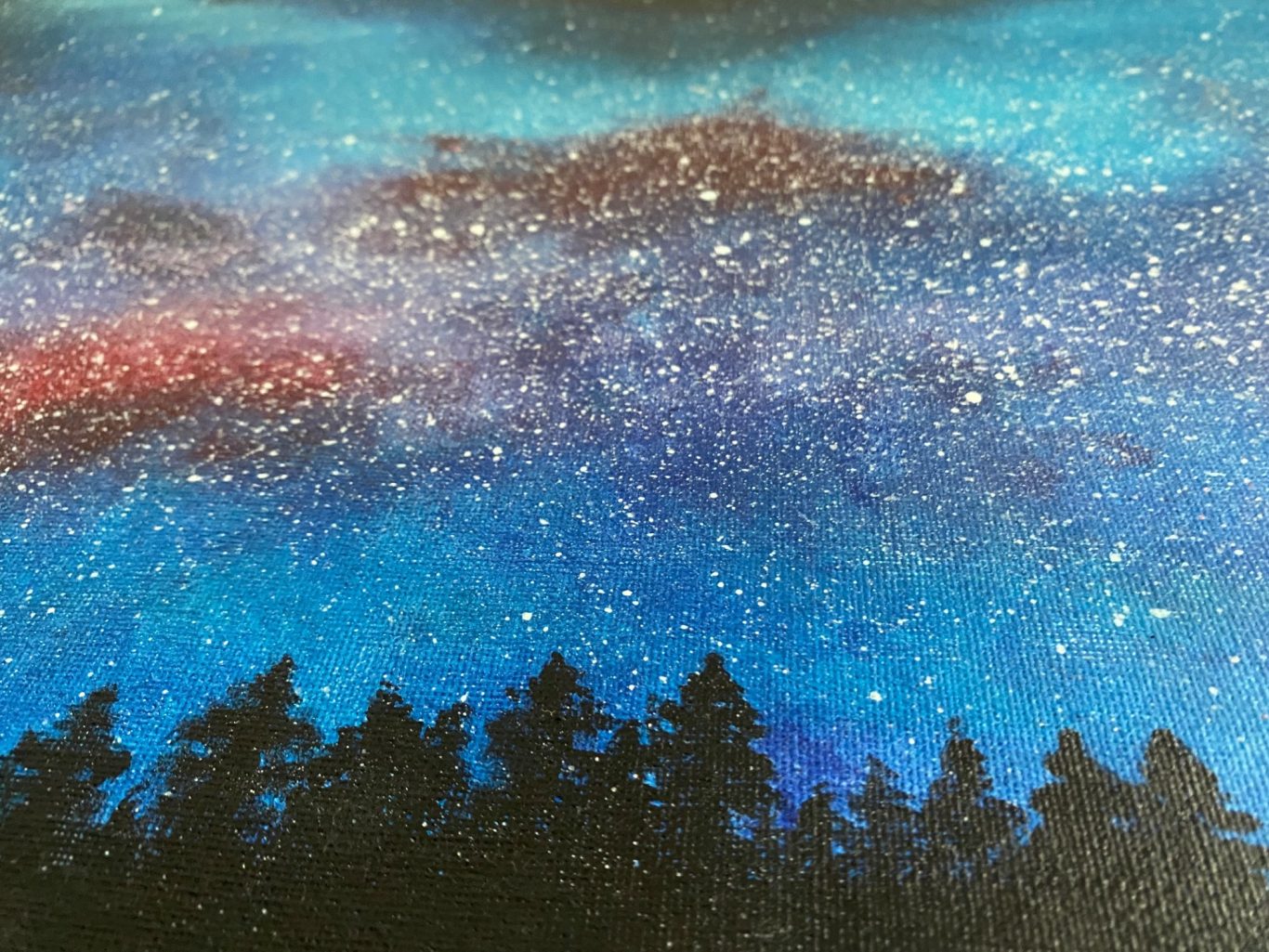 Sternenhimmel über einem silhouettierten Wald mit schimmernden Farben.