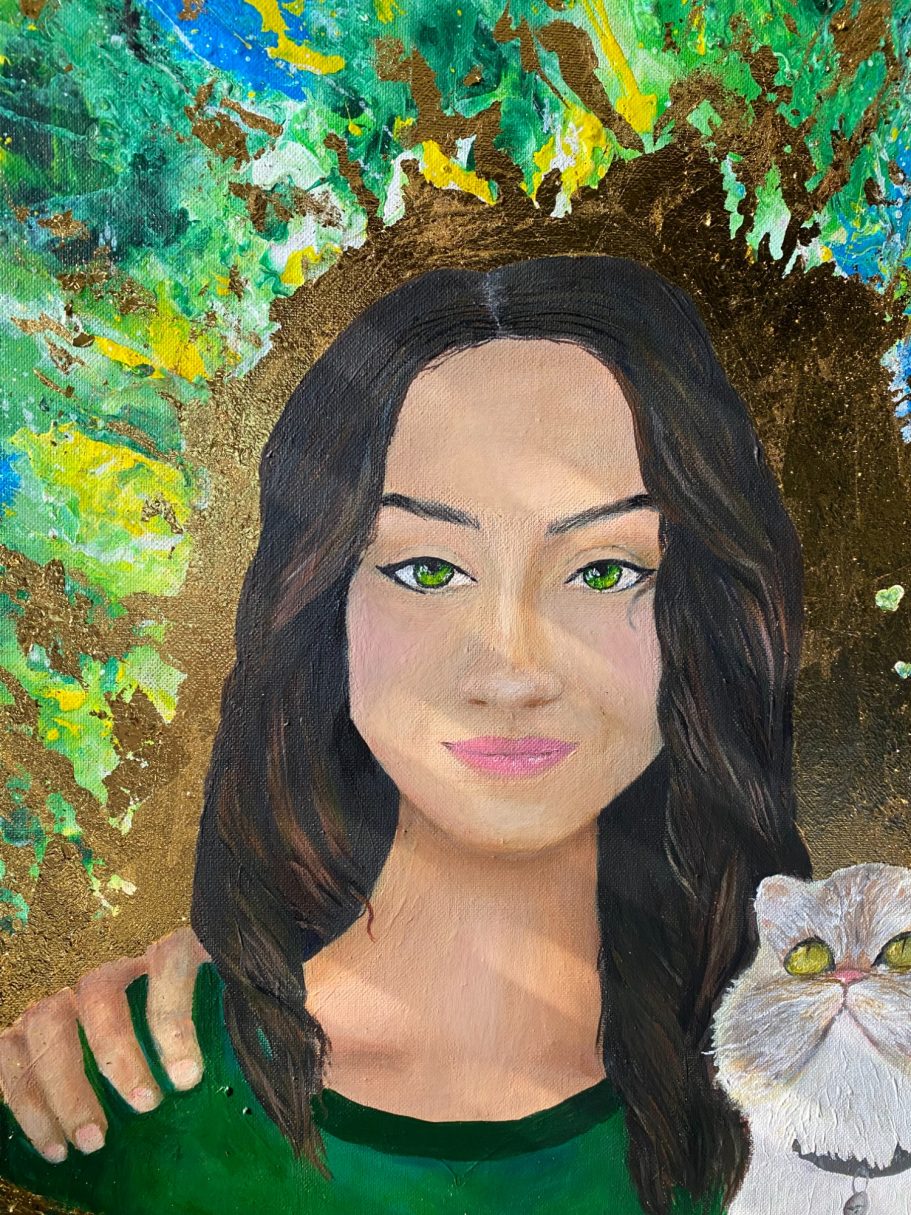 Porträt einer Frau mit langen, dunklen Haaren und grünem Oberteil, hält eine Katze.