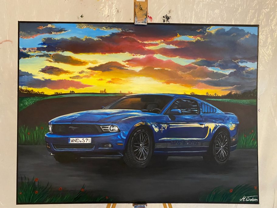 Ford Mustang Ein blauer Sportwagen vor einer bunten Landschaft mit Sonnenuntergang.