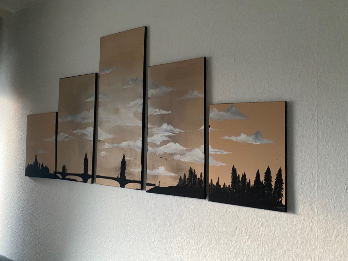 Abstraktes Wandbild mit stilisierten Silhouetten von Bäumen und einer Brücke bei Sonnenuntergang.