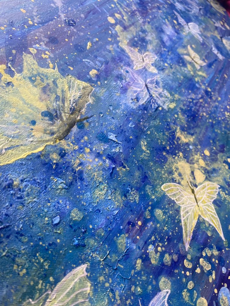 Bunte Flügel von Schmetterlingen auf einem blauen, splatter-artigen Hintergrund.