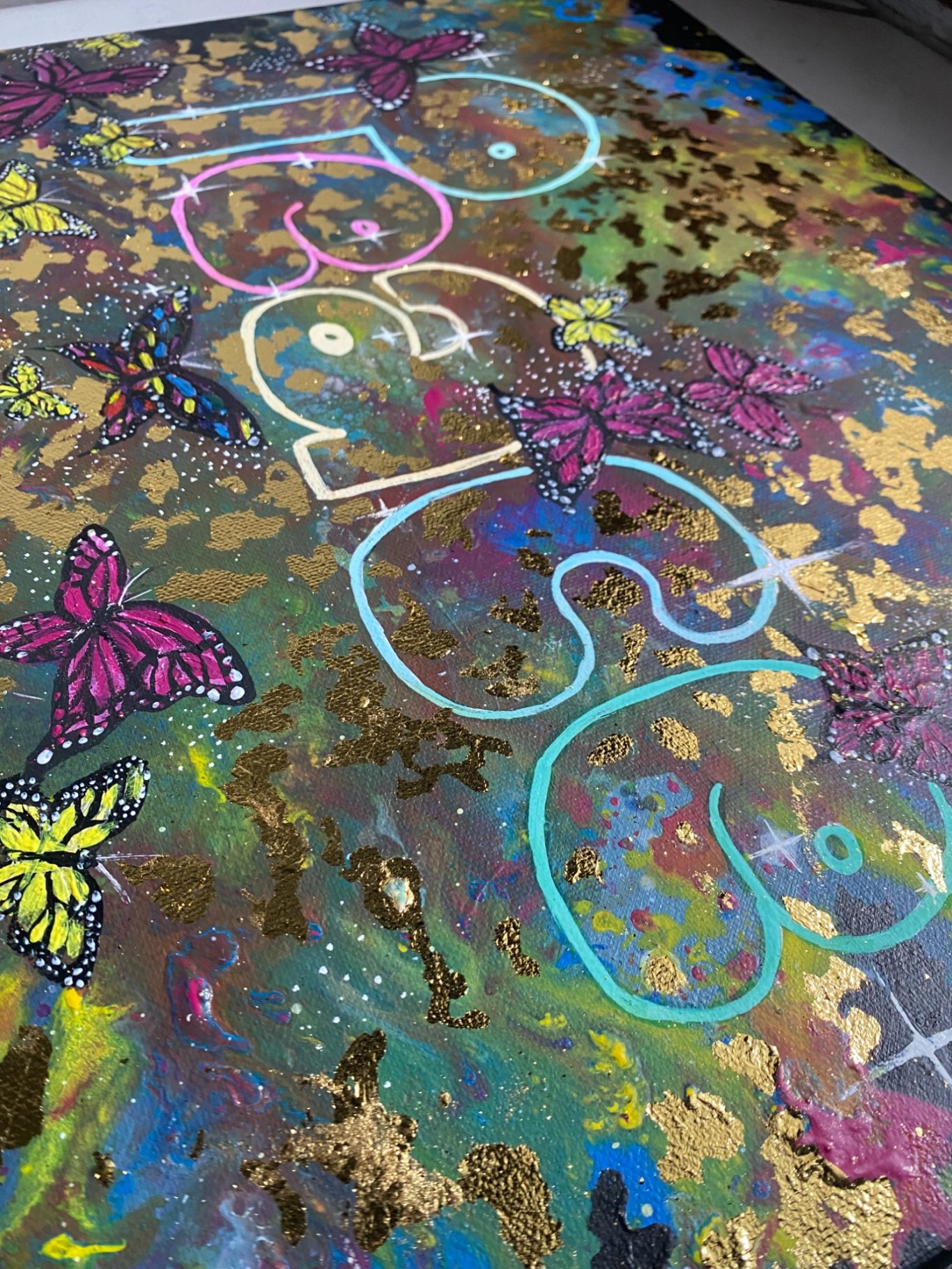 Farbenfrohes Kunstwerk mit Schmetterlingen und dem Wort "Peace".