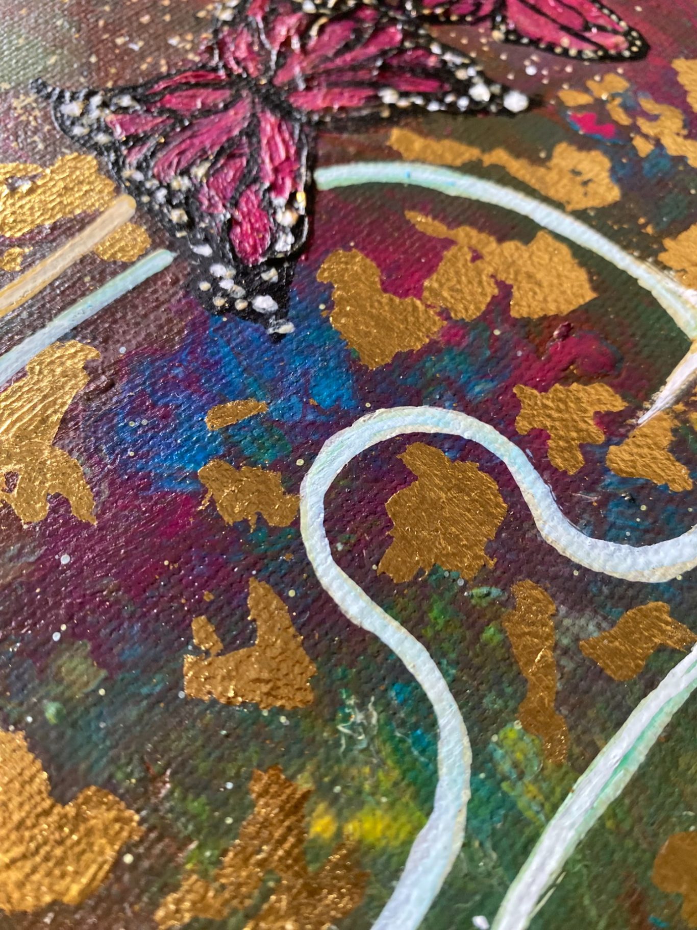 Bunte Malerei mit Schmetterling und goldenen sowie bunten Farbklecksen.