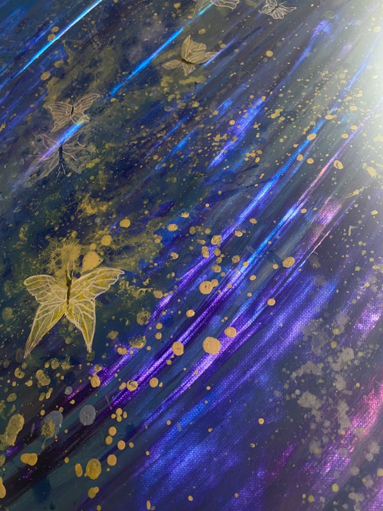 Bunte abstrakte Textur mit goldenen und blauen Akzenten sowie einem Schmetterling.