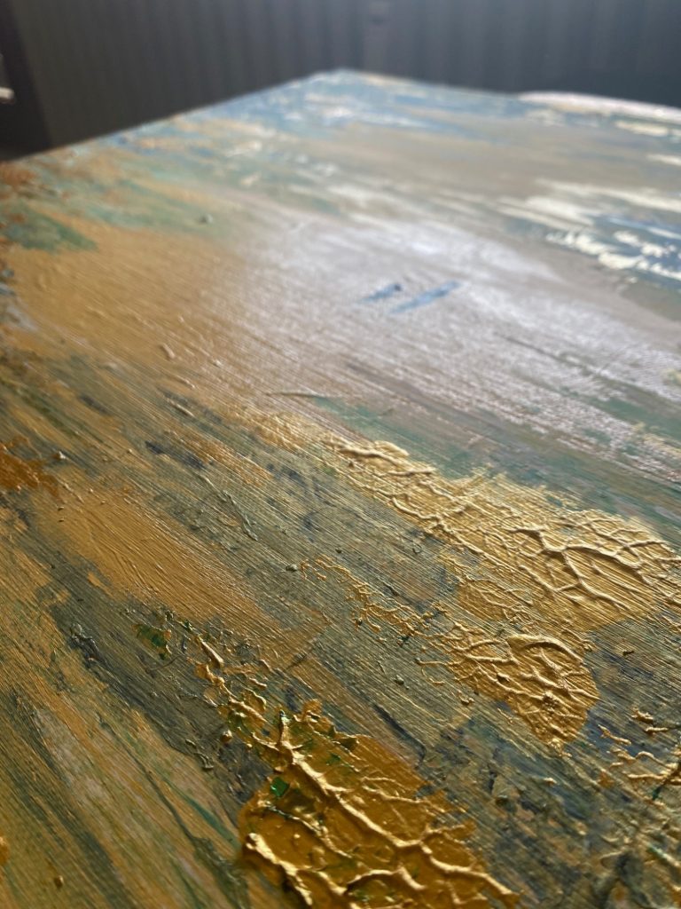 Detailansicht einer strukturierten, glänzenden Oberfläche mit blauen und goldenen Akzenten.