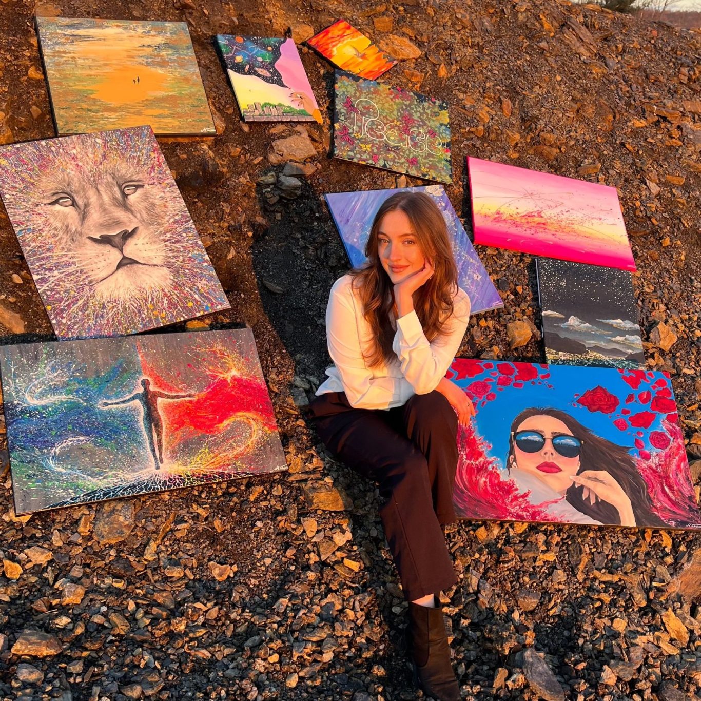 Marcelina Wodzien Portrait , umgeben von bunten, einzigartigen Acrylgemälden in der Abendsonne.