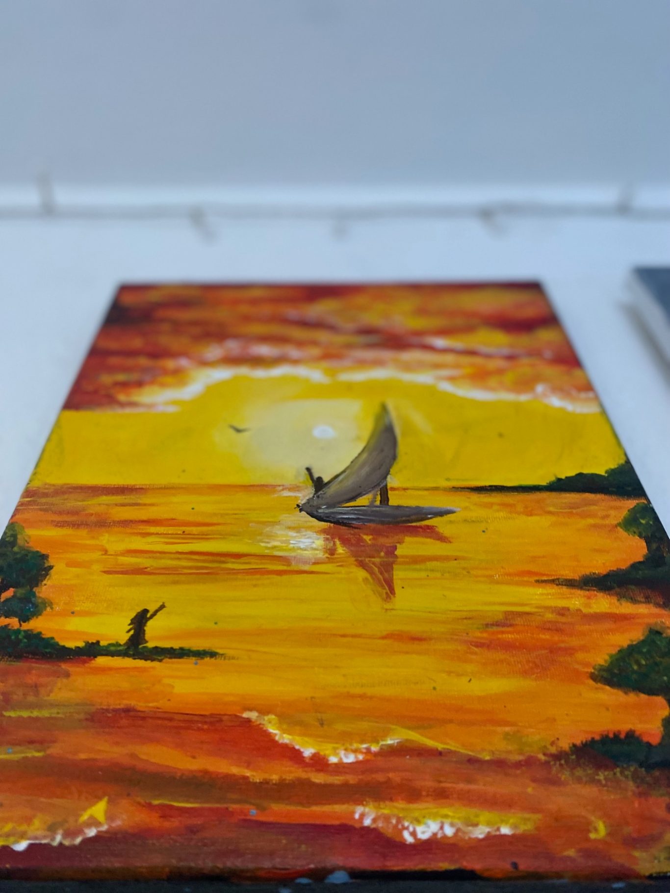 Eine malerische Landschaft mit einem Boot auf dem orangefarbenen Wasser während des Sonnenuntergangs.